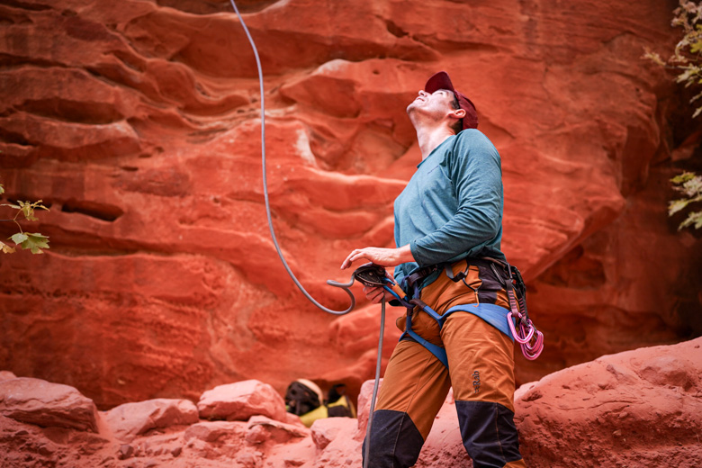 A man belaying a climber in a canyon in Zion