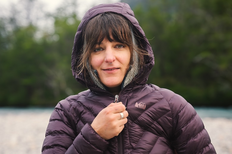 A woman stays cozy warm in a hooded down jacket. 