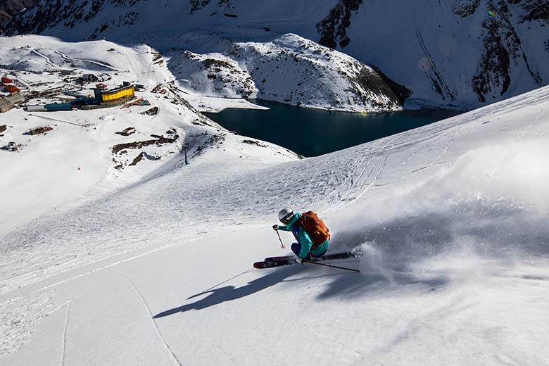 A skiier makes turns on a sunny day in Portillo, Chile.