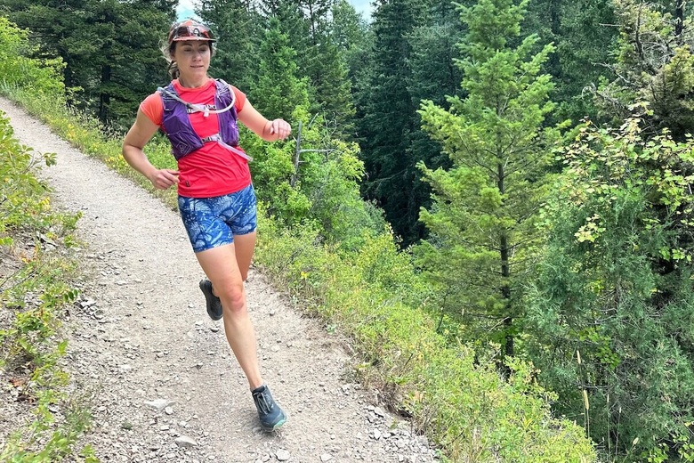 A runner comes down the trail wearing a pair of Altra Lone Peak 9 shoes