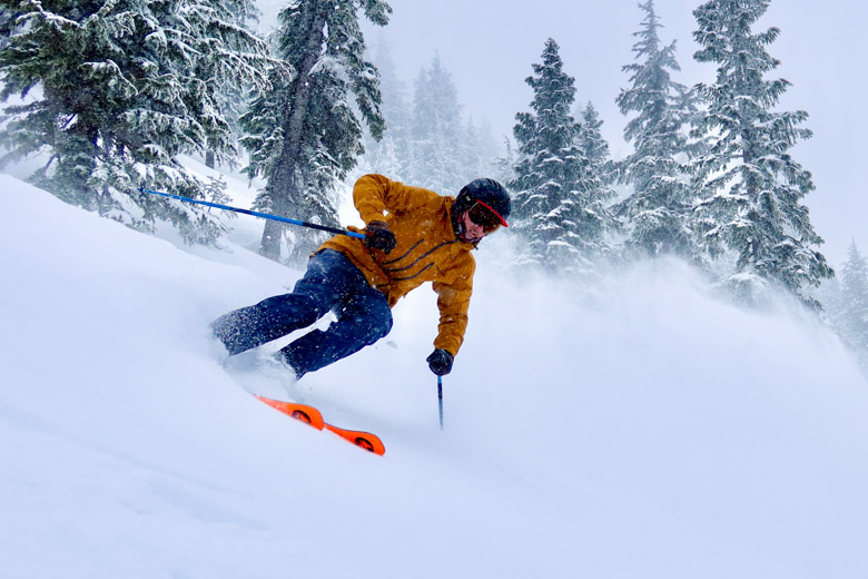 A skier comes down a powdery slope at high speed
