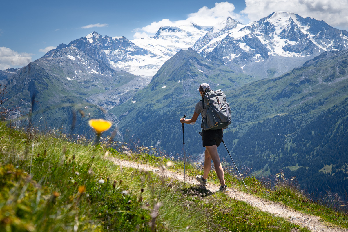 A woman backpacks on a trail in Switzerland
