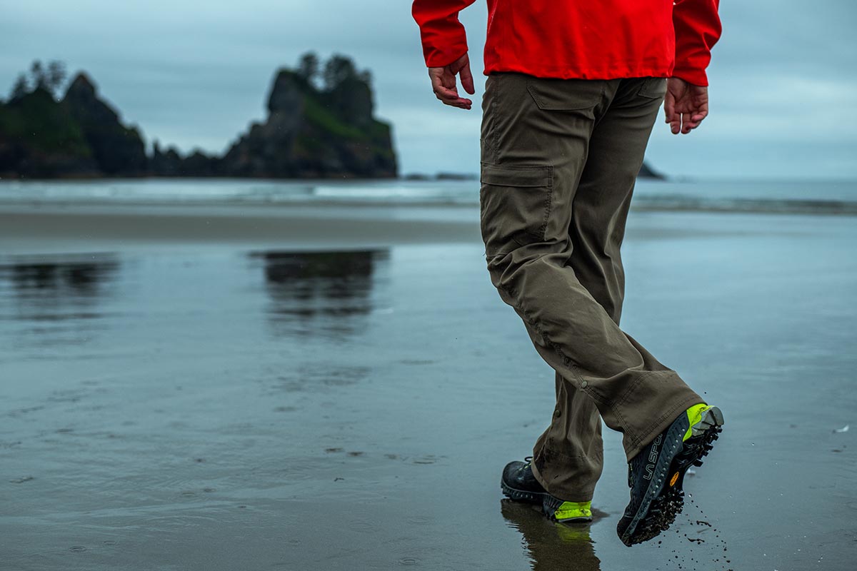 A man hiking on a beach with the La Sportiva Spire