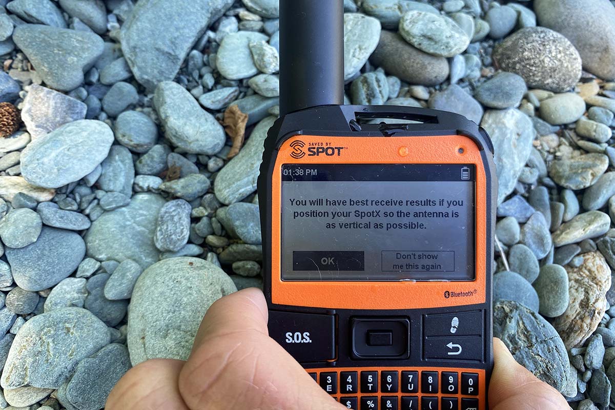 A close up of the SPOT X satellite messenger sitting on small rocks