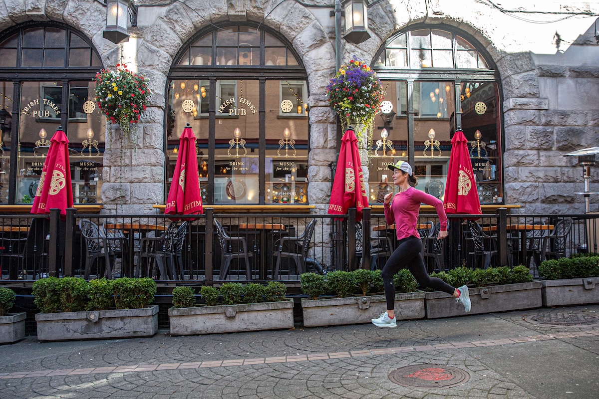 A runner runs across the frame testing running shoes in a city environment