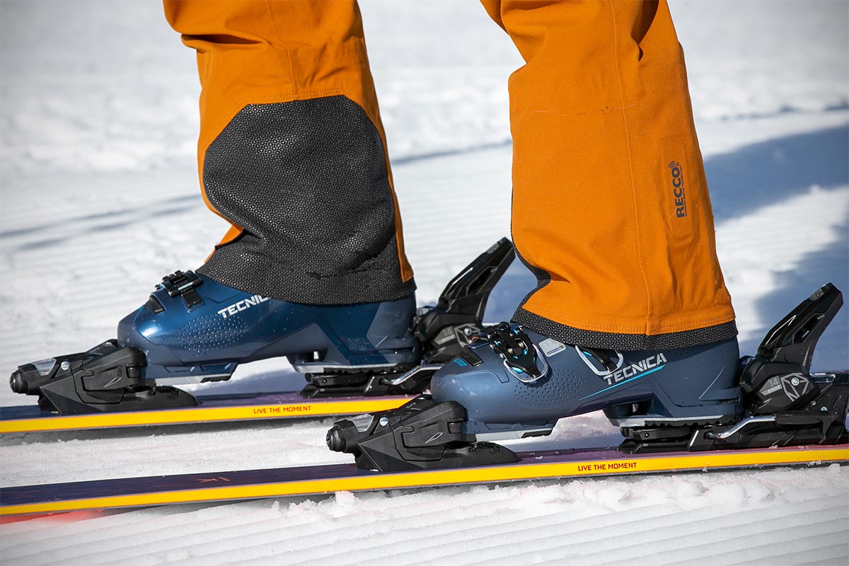 A pair of downhill boots are clipped into their skis, and ready to ride.