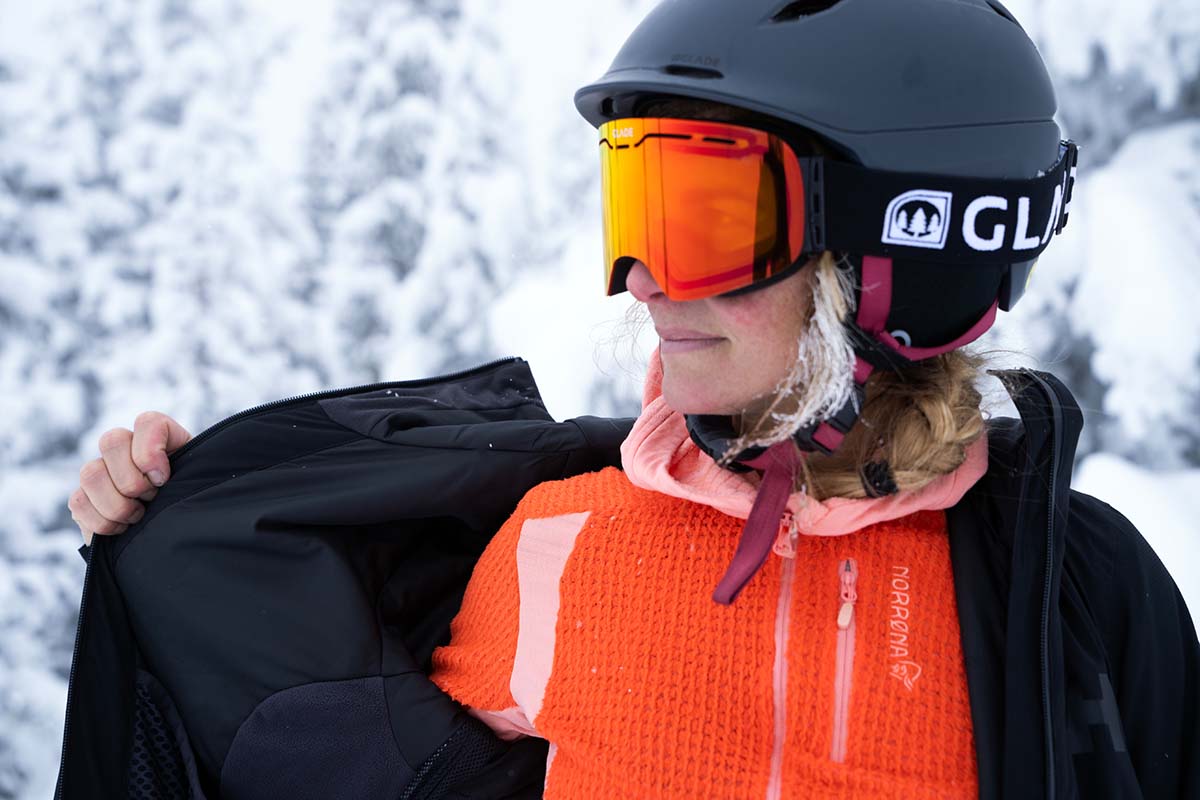 A skiier shows off her bright orange Norrona layer.