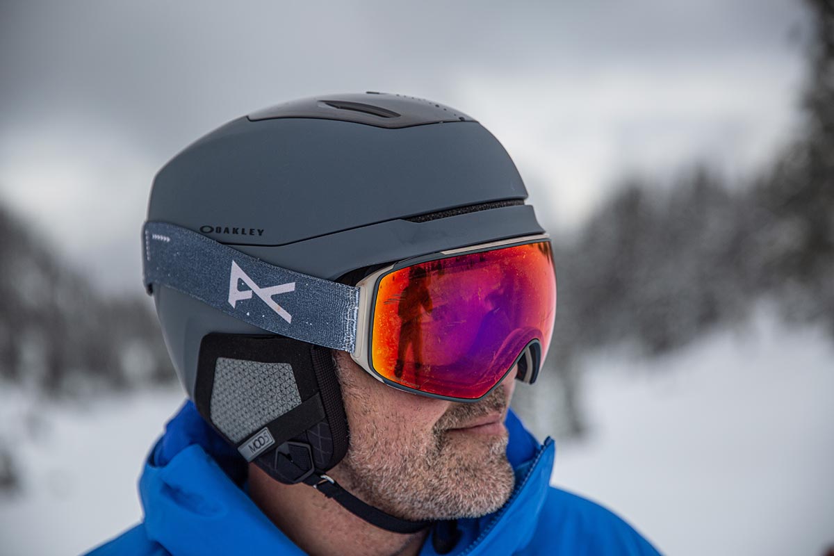 A man wearing a grey ski helmet with goggles