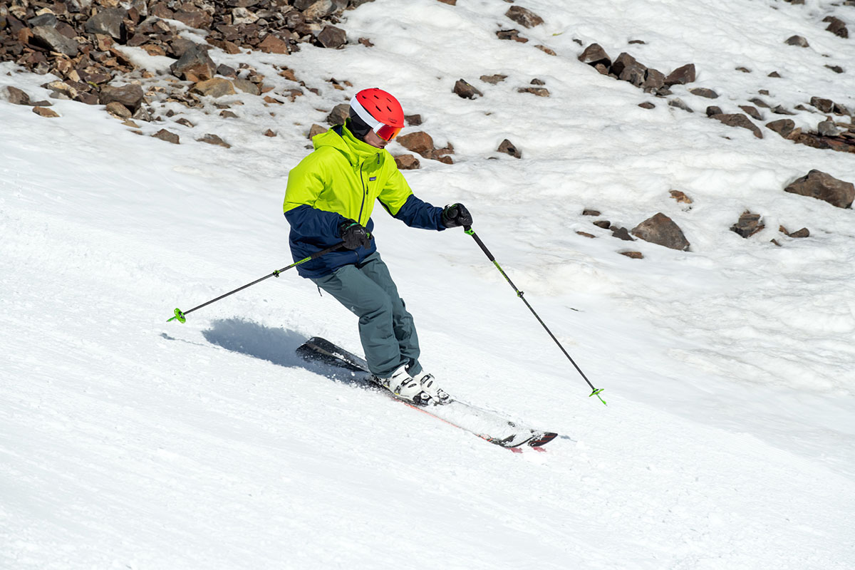A man skiing down a slope wearing a red ski helmet