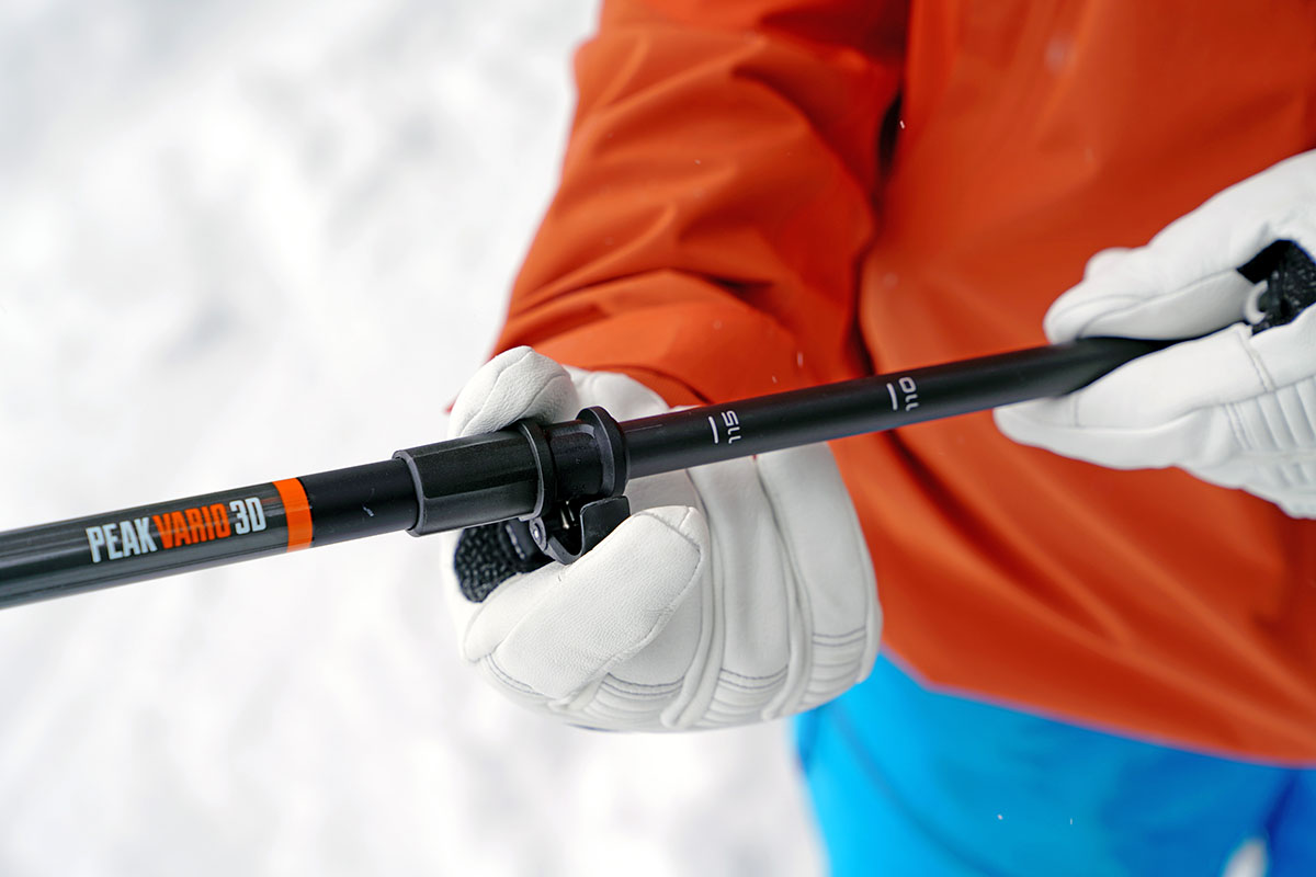 A close up of a hand adjusting the length of a ski pole