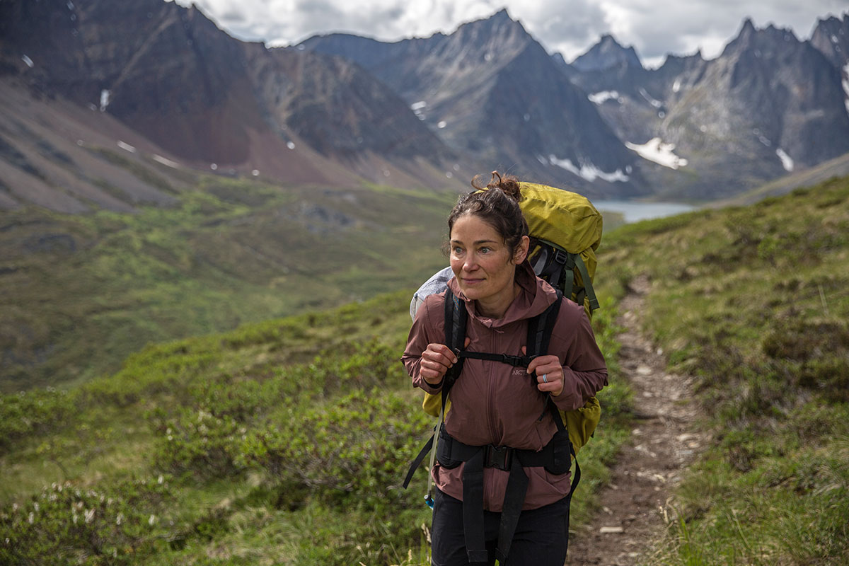 a woman smiling hiking in the mountains