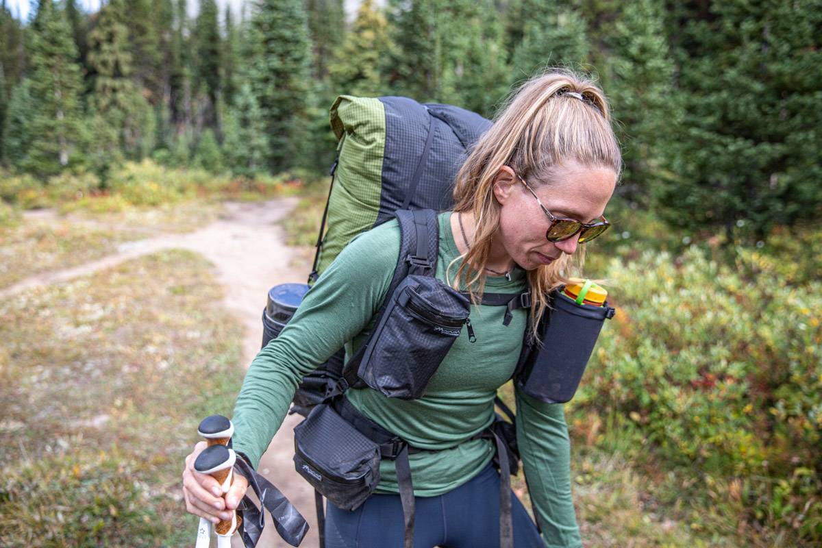 A woman on a trail wearing a green baselayer