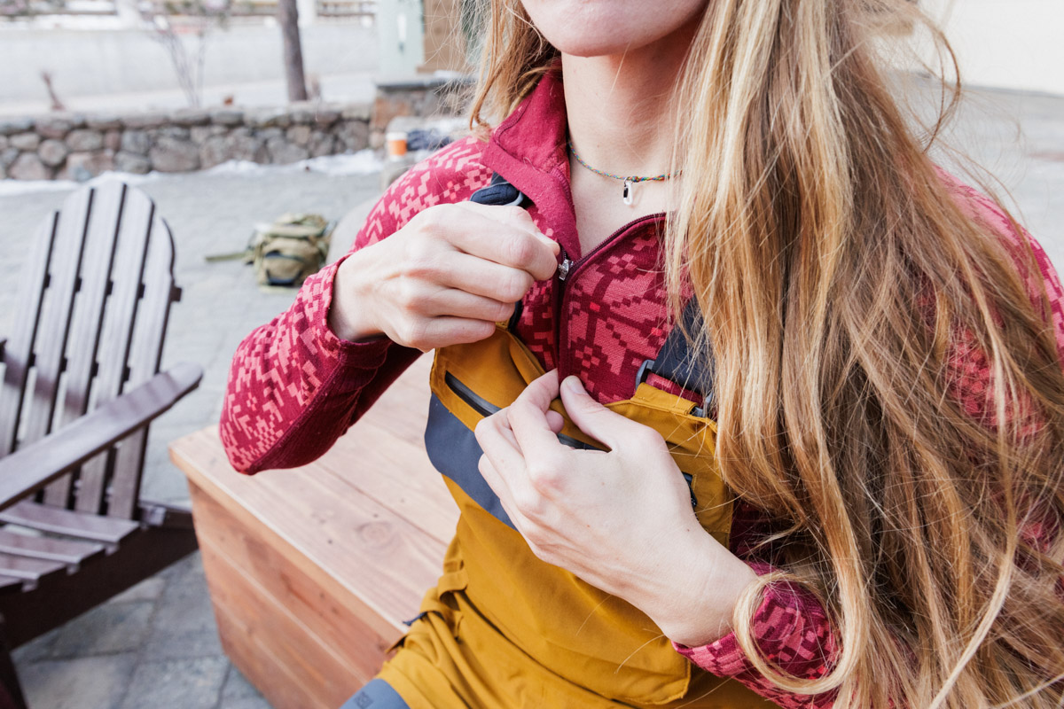 A woman zipping up a pink baselayer