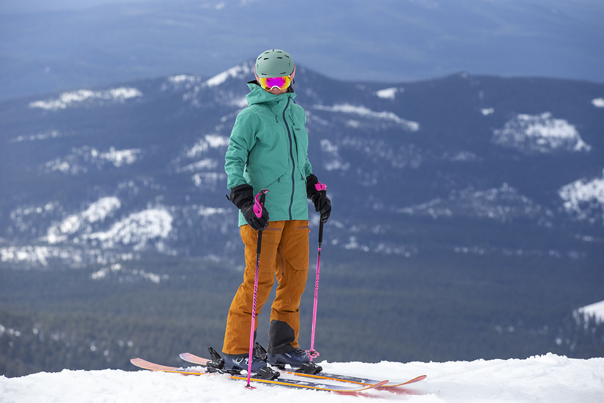 A woman on skis while wearing a green ski jacket