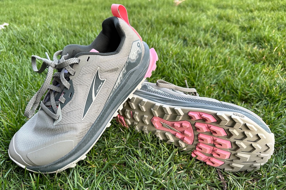 The side view of a pair of Altra Lone Peak 9 shoes lying in the grass