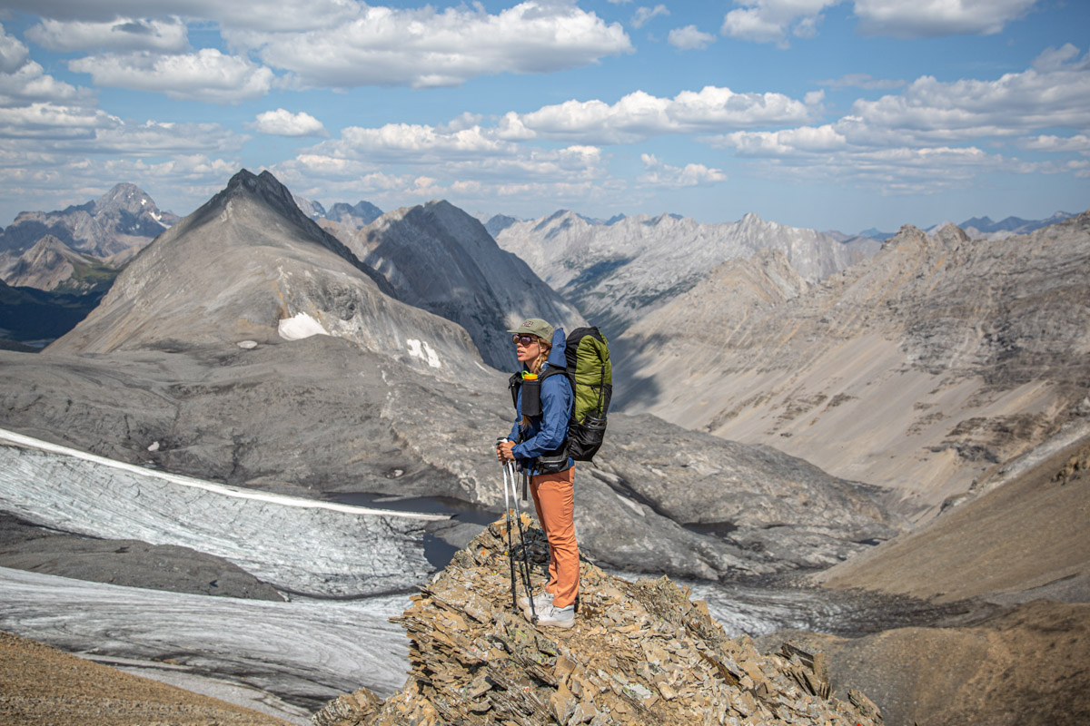 A woman standing on a ledge wearing white hiking boots
