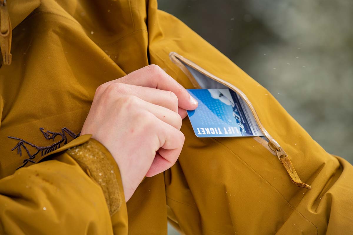 A tester eases a ski pass into the zippered pocket on the upper arm of the coat.