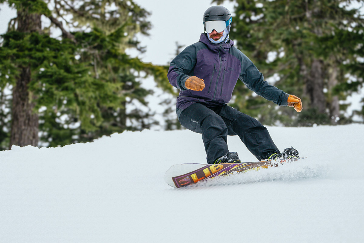 A man snowboarding wearing snowboard pants