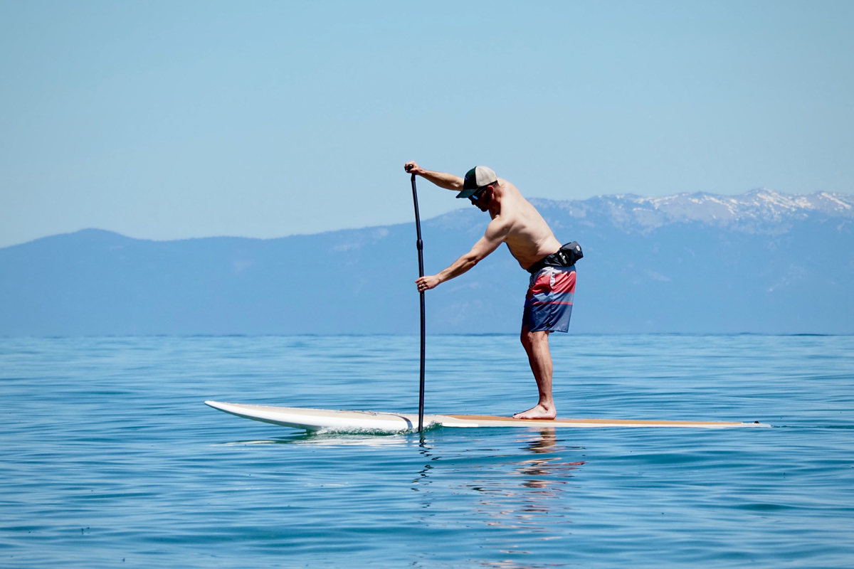 A man paddling across a lake quickly