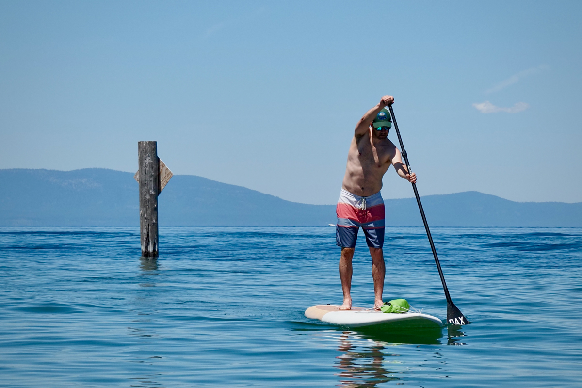 A man paddling the Dax DownDog stand up paddle board on Lake Tahoe