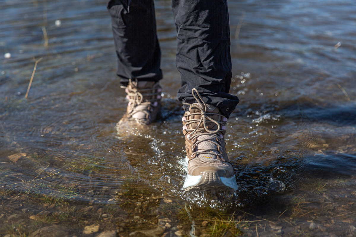 A pair of hiking boots walking through shallow water