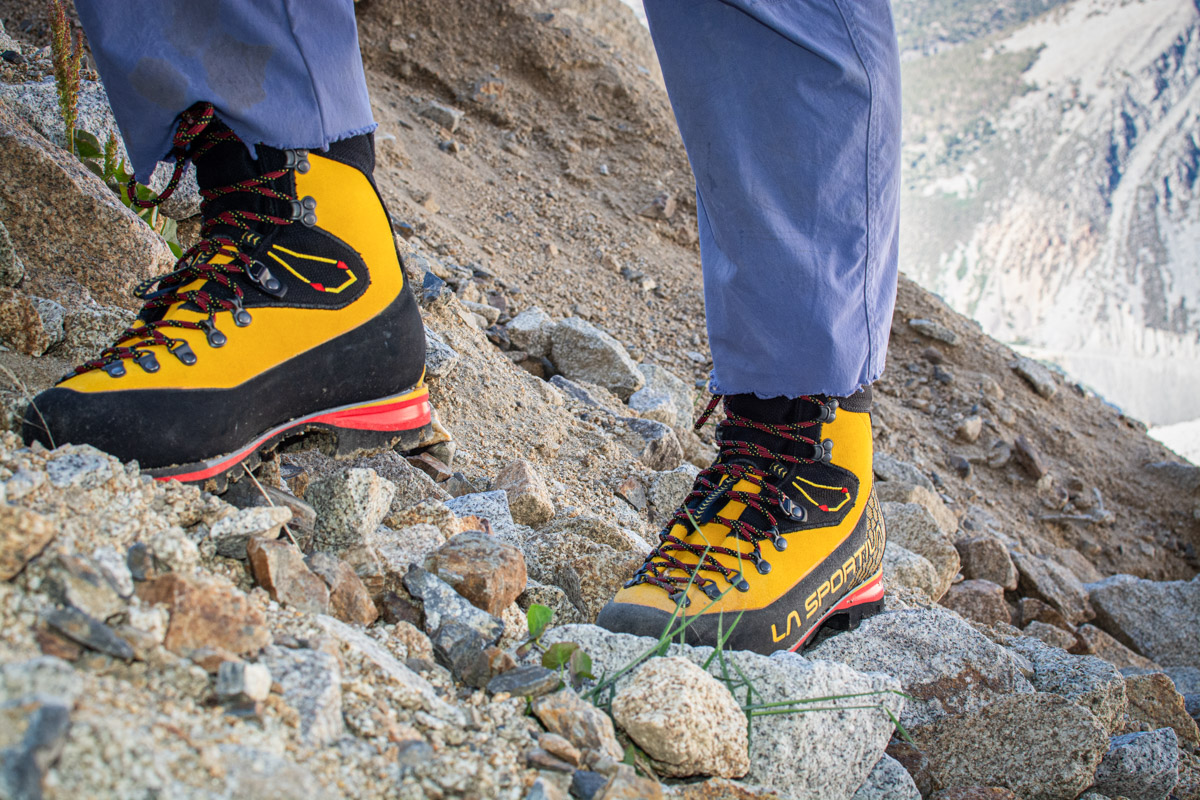 A man hikes across scree with the La Sportiva Nepal Cube GTX boots