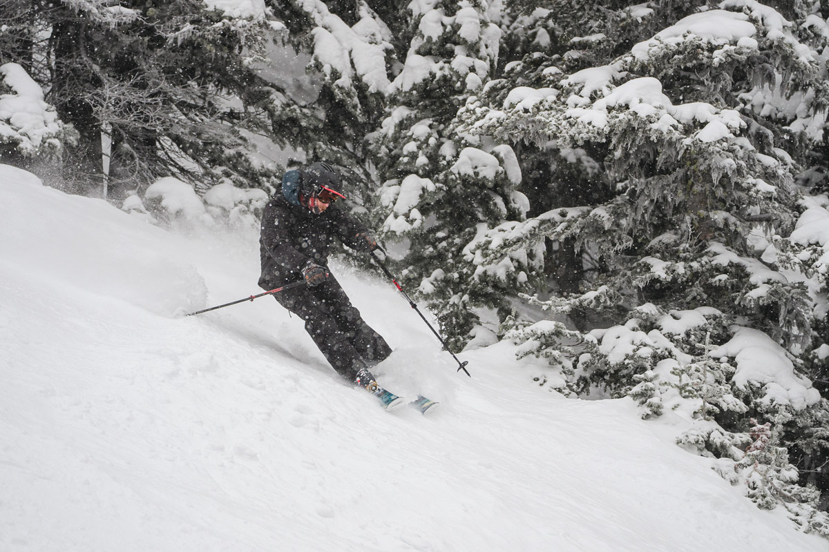 A man skiing quickly through the snow in ski boots