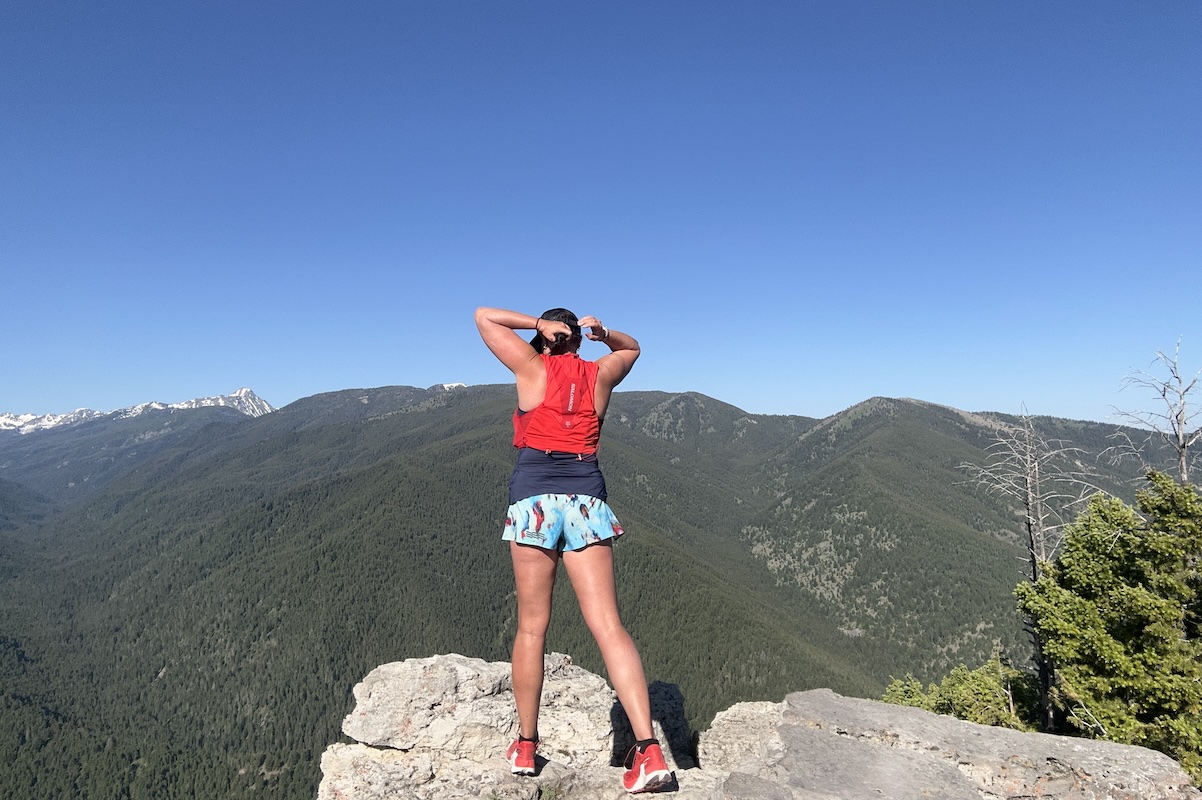 standing on a ledge in running clothes facing away from the camera 