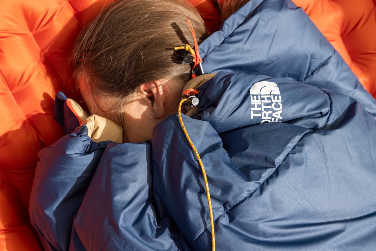 A woman snuggled into the Wawona Bed with the neck cinched to keep warm