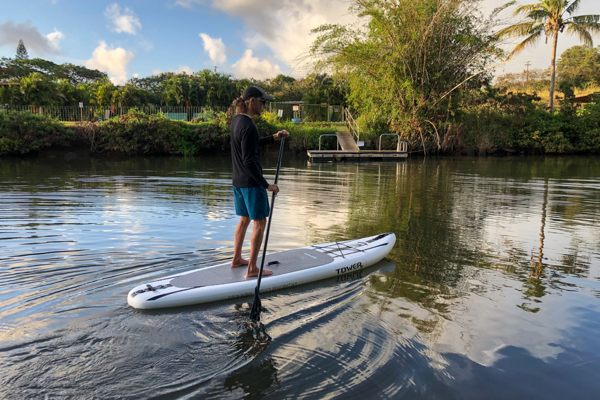 A man paddling a paddle board on still waters