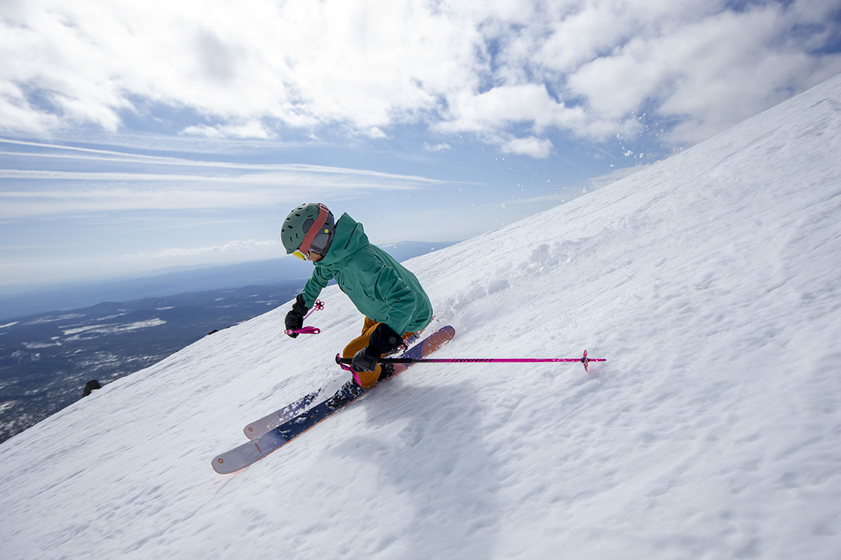 A woman skis down a steep slop on a sunny day