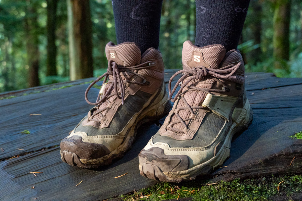 Close up of brown and pink Salomon hiking boots standing on a log