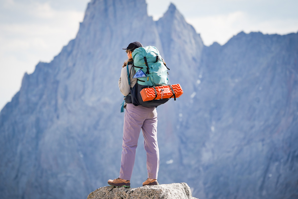 REI Co-op Trailmade 60 (wearing pack in front of cliff)