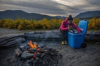 A woman opens the Yeti Roadie 48 cooler during a test trip 